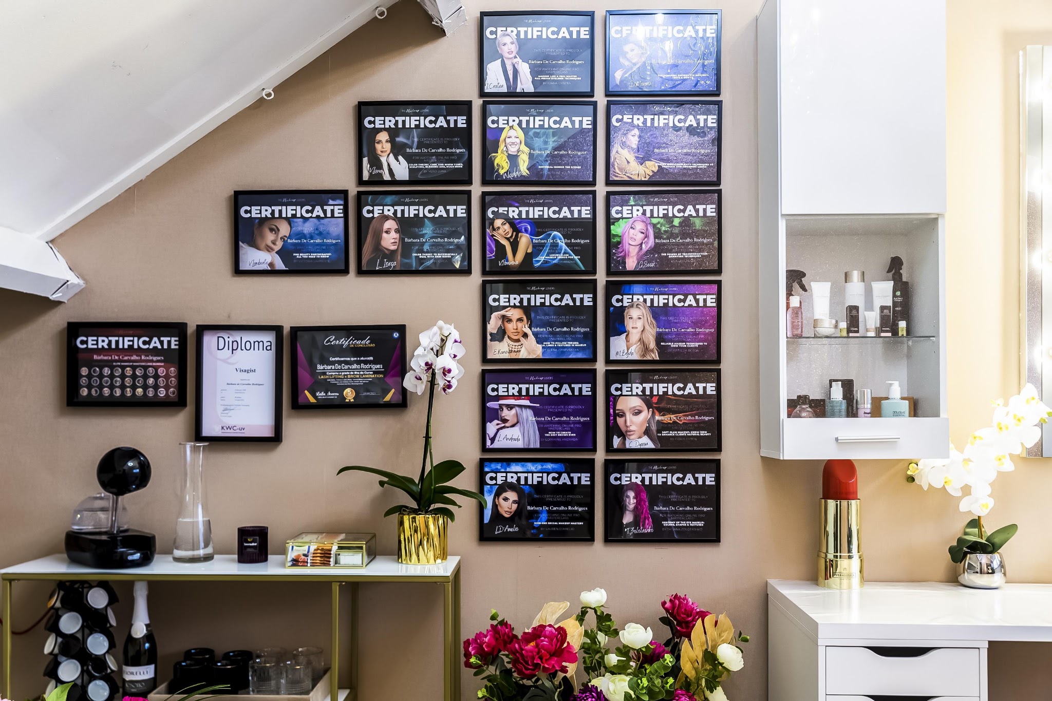 De wand met ingelijste certificaten in de salon