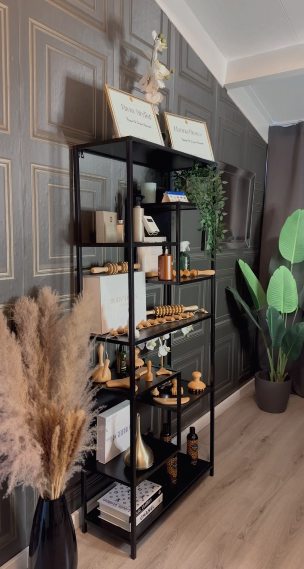 Zwarte kast met producten, pampasgras en een plant tegen de donkere wand