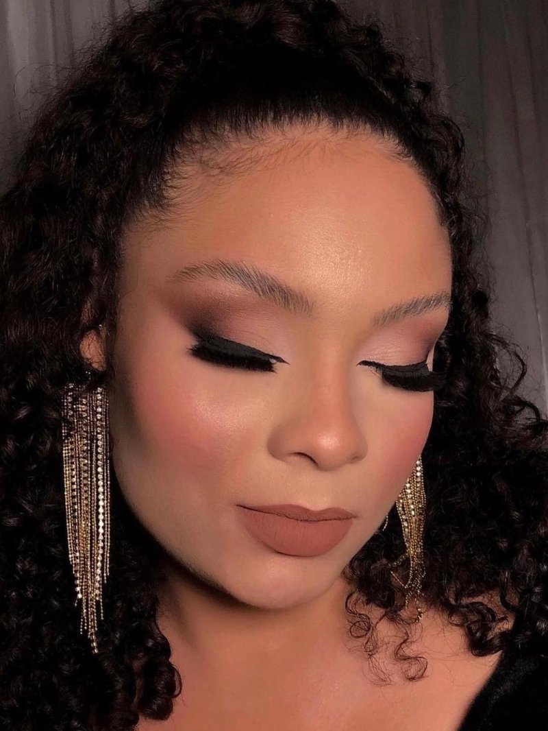 Avondmake-up met goudkleurige oogschaduw en lange wimpers
